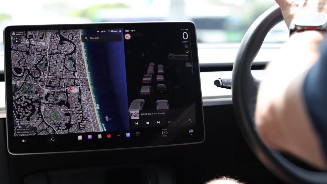 Driver interacts with a car's touchscreen navigation system while driving, showcasing modern technology and user interface