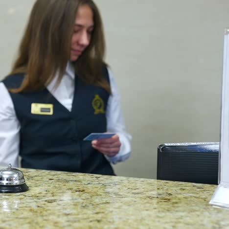 man and receptionist at counter. young man paying for hotel room at reception
