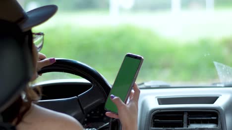 Vista-Por-Encima-Del-Hombro-De-Una-Chica-En-Un-Auto-Detrás-Del-Volante-Desplazándose-Por-El-Teléfono