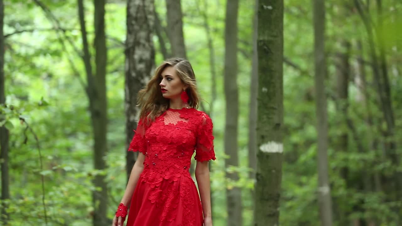Beautiful Girl Walking In Forest. Beautiful girl in red long dress walking in forest