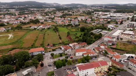 aerial - pueblo de paços de ferreira, mostrando el paisaje con una mezcla de áreas residenciales, carreteras y campos verdes - portugal