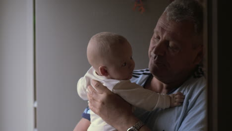 grandfather holding his newborn granddaughter