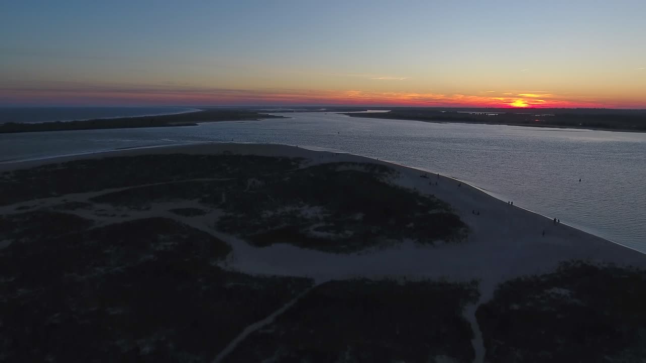 puesta de sol naranja en la playa, marea alta, cielo de algodón de azúcar
