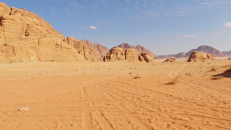 wide angle empty view of desert sand below sandstone cliffs