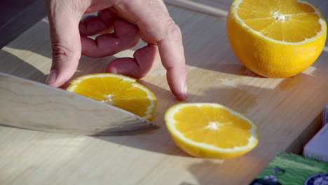 cutting fresh oranges on a wooden board