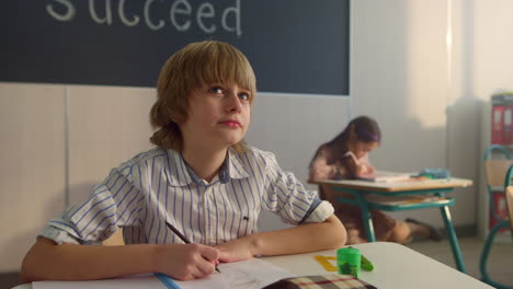 Colegial-Tomando-Notas-En-Un-Cuaderno.-Niño-Inteligente-Escribiendo-En-Un-Cuaderno-De-Ejercicios-En-La-Lección