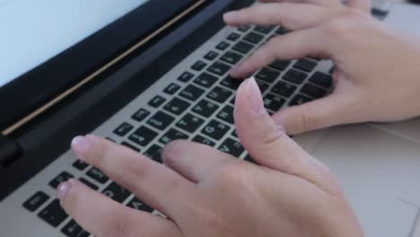 Front view of student's hands typing on a laptop keyboard. E-learning, research, or academic