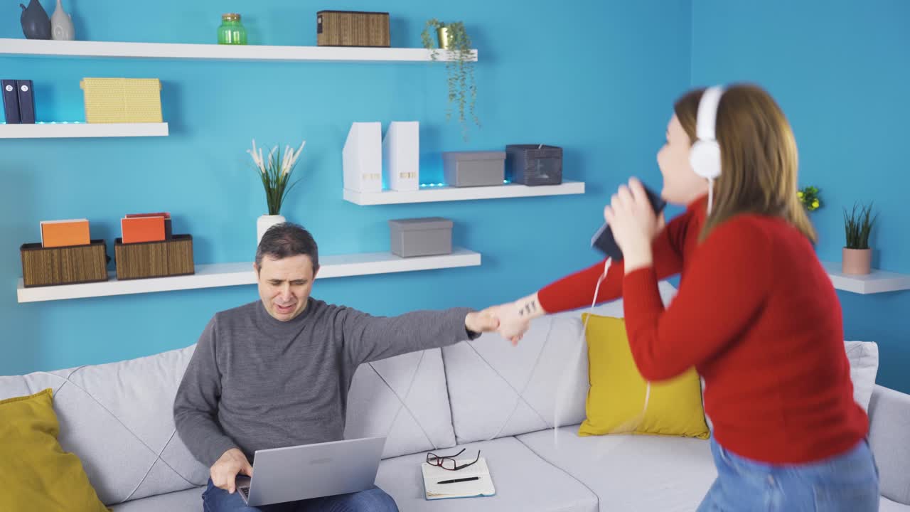 집에서 노래하는 소녀는 강제로 아버지를 들어 올리고 그들은 춤을 춘다.