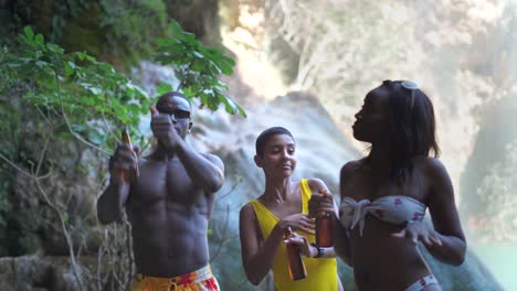 multiracial friends with beer dancing near lake