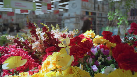 vista de una vibrante exhibición de flores de varios colores en un centro comercial. este video muestra la belleza y la diversidad de arreglos florales con un fondo borroso, mejorando el enfoque en las flores