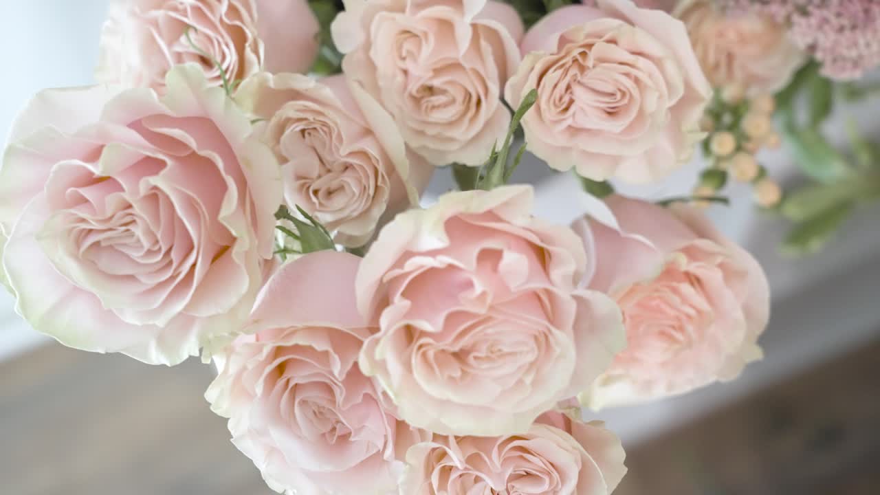 acercándose a un ramo de rosas rosadas en un banco de floristería