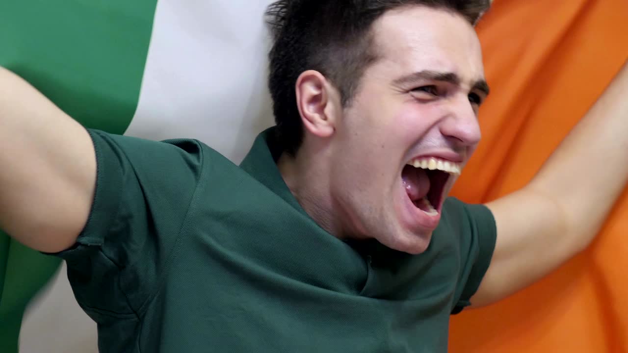 아일랜드의 젊은이가 슬로모션으로 아일랜드의 발을 들고 축하하고 있습니다.