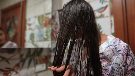 mujer secándose el cabello en el baño