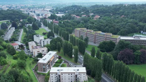 aerial of houses for large families, by figini and pollini in 40s, ivrea olivetti industrial city, framed by green lawns, drone, slow motion.