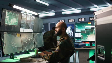 oficial usando equipo de monitoreo en la base de operaciones en el enemigo
