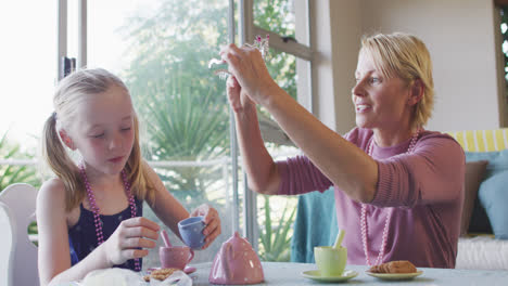 Side-view-of-Caucasian-woman-playing-with-her-daughter-at-home