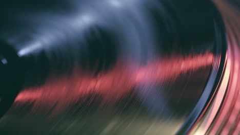 the player vinyl turntable close-up on a background of red and blue lights. fragment of a rotating black vinyl record player. loop