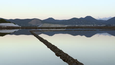 Pan-Up-De-Las-Salinas-De-Ibiza-Y-El-Reflejo-En-El-Agua,-Ibiza,-España