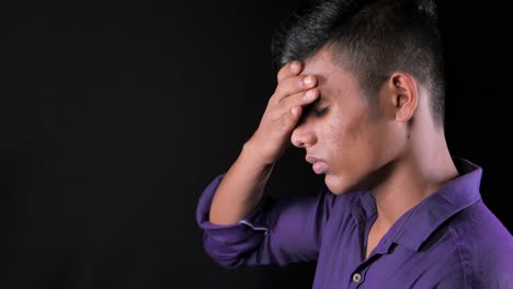 teenage boy with head in hand