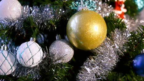 panning shot of decorative ornaments - tinsel on a christmas tree