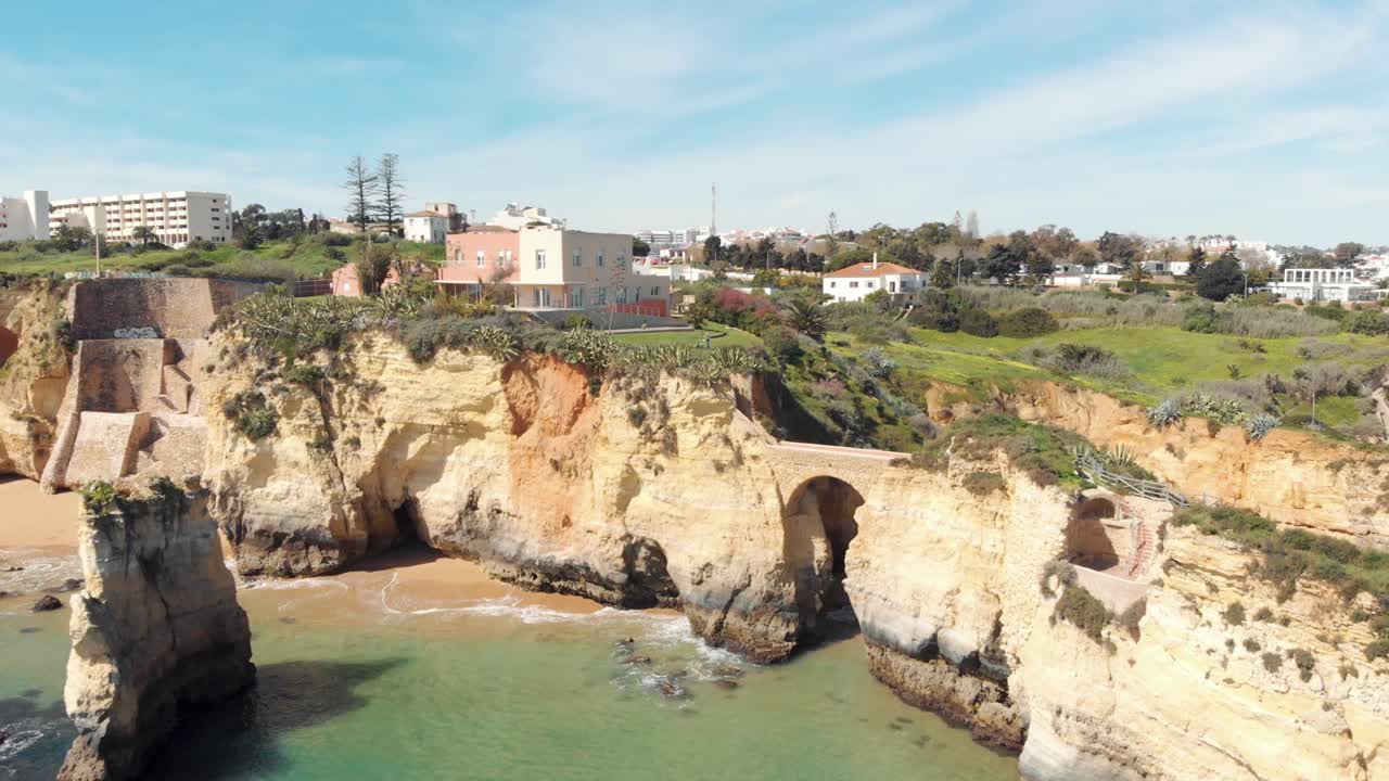 idílica playa de estudante frente al mar con puente romano cerca de la costa, algarve, portugal - tiro aéreo sobrevuelo