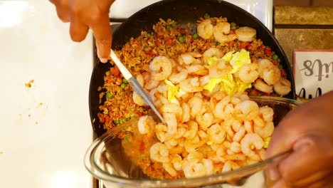 añadiendo las gambas salteadas a la fritura