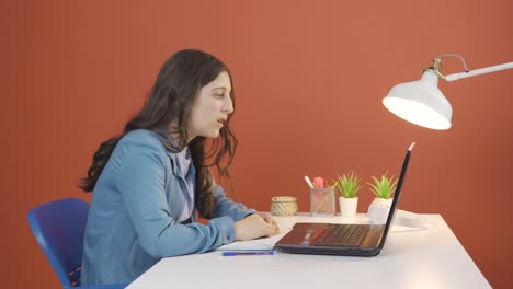 la mujer joven que mira la computadora portátil se frustra.