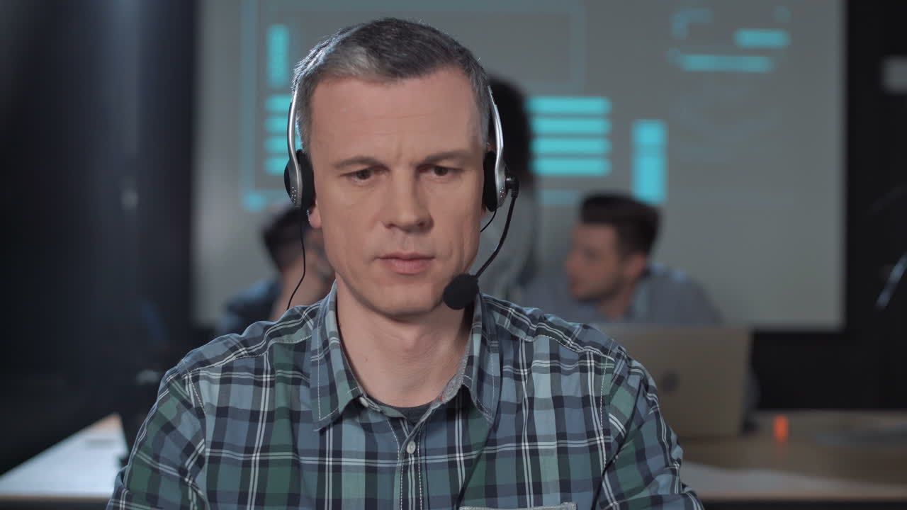 Man in headset working in a call center or support office