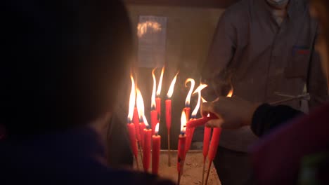 people lighting candles in man mo temple