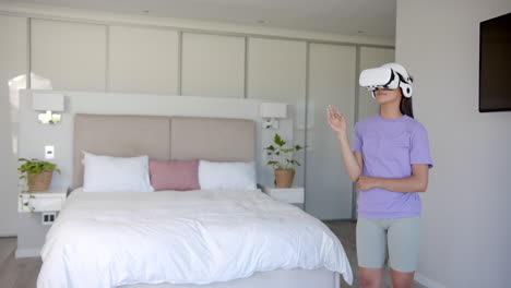 using vr headset, woman exploring virtual reality in modern bedroom, copy space