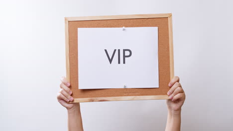 Woman's-hand-shows-the-paper-on-board-with-the-word-VIP-in-white-studio-background-with-copy-space