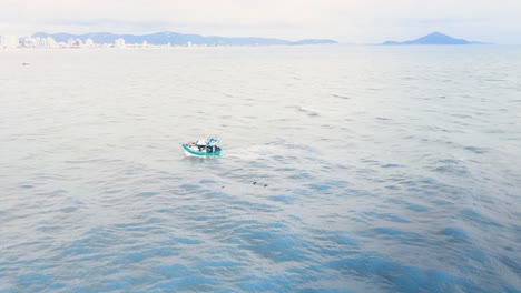 Tradicional-wooden-fisher-boat-in-the-ocean-with-seagulls-passing-by