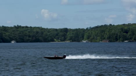 fast boat speeding along muskoka lake. travelling right to left
