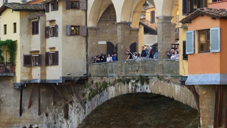 tourists overlooking river arno from ponte vecchio