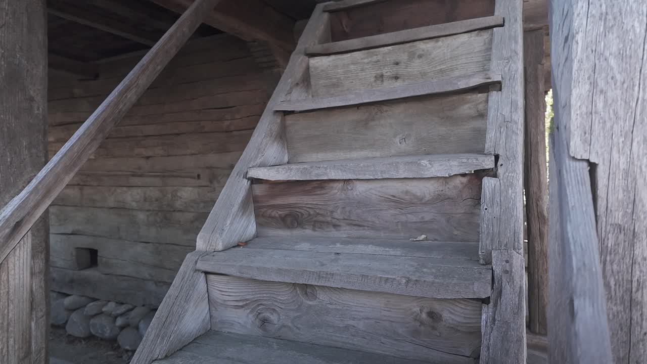 External wooden stairs lead to upper floor of rustic traditional house PAN-UP
