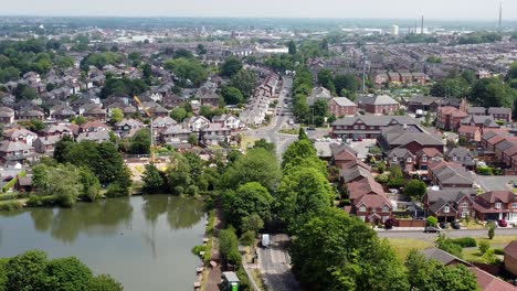 Establishing-aerial-view-above-detached-neighbourhood-property-flyover-to-lakeside-red-brick-British-townhouse-building-site