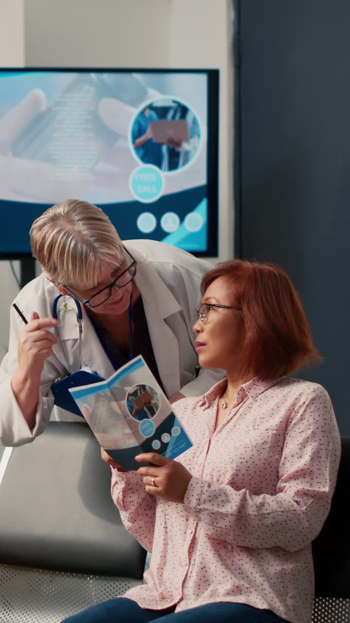 Vertical video: Elderly physician and asian patient talking about healthcare
