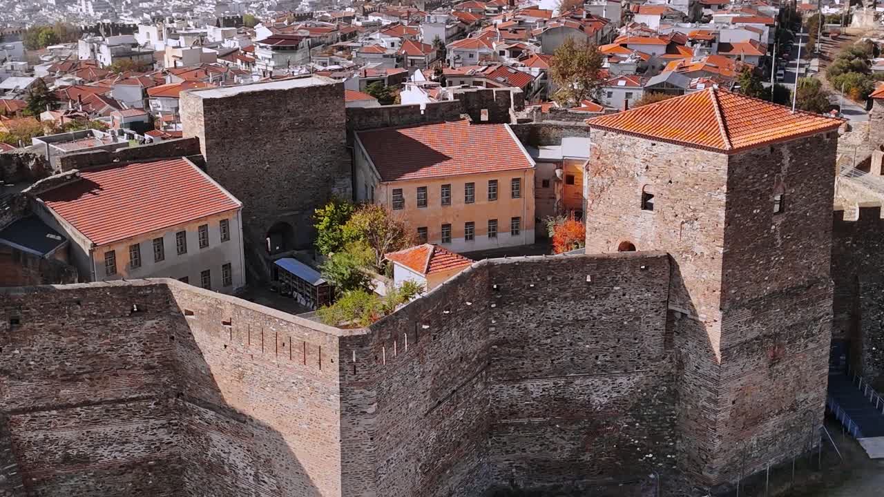 Complesso castellano storico in Grecia con tetti rossi e la città circostante