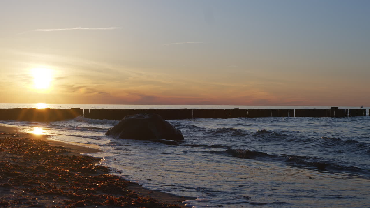 Beach with small waves while beautiful sunset, 4k