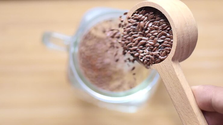 Slow motion of pouring flax seeds into a glass of water