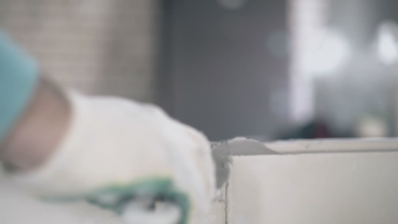 장갑을 입은 남자가 작은 푸티 칼을 들고 벽을  ⁇ 습니다.