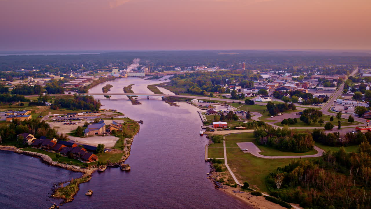 Drone shot flying in over lake michigan towards the city of Manistique Michigan located in the upper peninsula