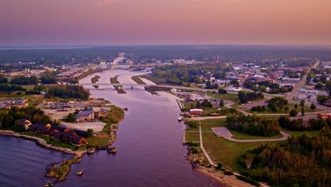 drone shot flying in over lake michigan towards the city of manistique michigan located in the upper peninsula