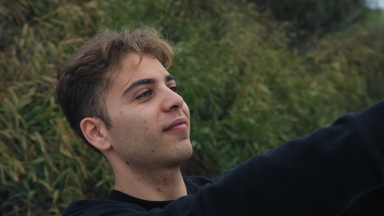 joven toma selfies de vanidad con su teléfono inteligente afuera en la naturaleza