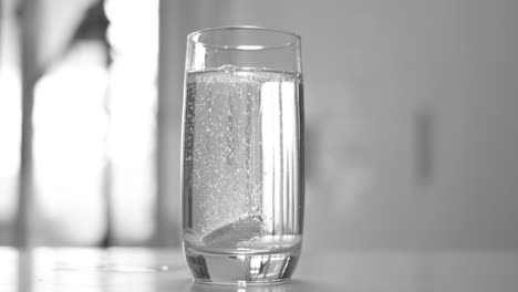 effervescent aspirin pill in a glass of wate. soluble tablet shot on super slow motion camera 1000 fps.