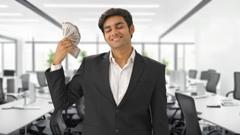 hombre de negocios indio usando dinero como ventilador feliz