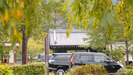 cars parked outside of a gate surrounded by green in kyoto, japan 4k