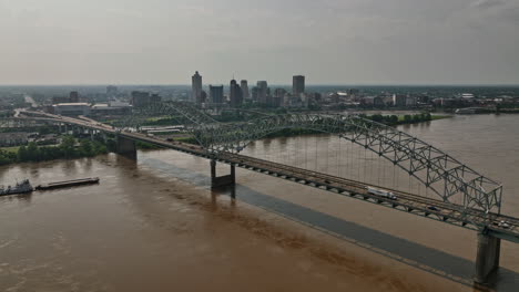 Memphis-Tennessee-Aerial-V35-Flyover-Mississippi-River-Und-Hernando-De-Soto-Bridge,-Aufnahme-Der-Innenstadt-Und-Eines-Schubbootes,-Das-Einen-Lastkahn-Auf-Der-Wasserstraße-Schiebt-–-Aufgenommen-Mit-Mavic-3-Cine-–-Mai-2022