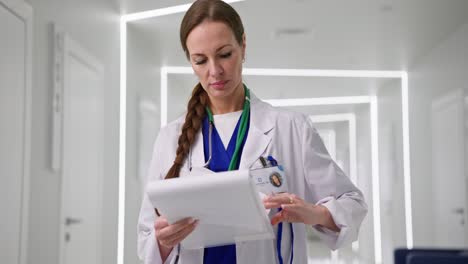 médico revisando registros médicos en el pasillo del hospital