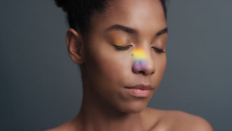 retrato multicolor hermosa mujer afroamericana con luz colorida que se refleja en una piel suave y saludable atractivo concepto de cuidado de la piel femenino en fondo gris
